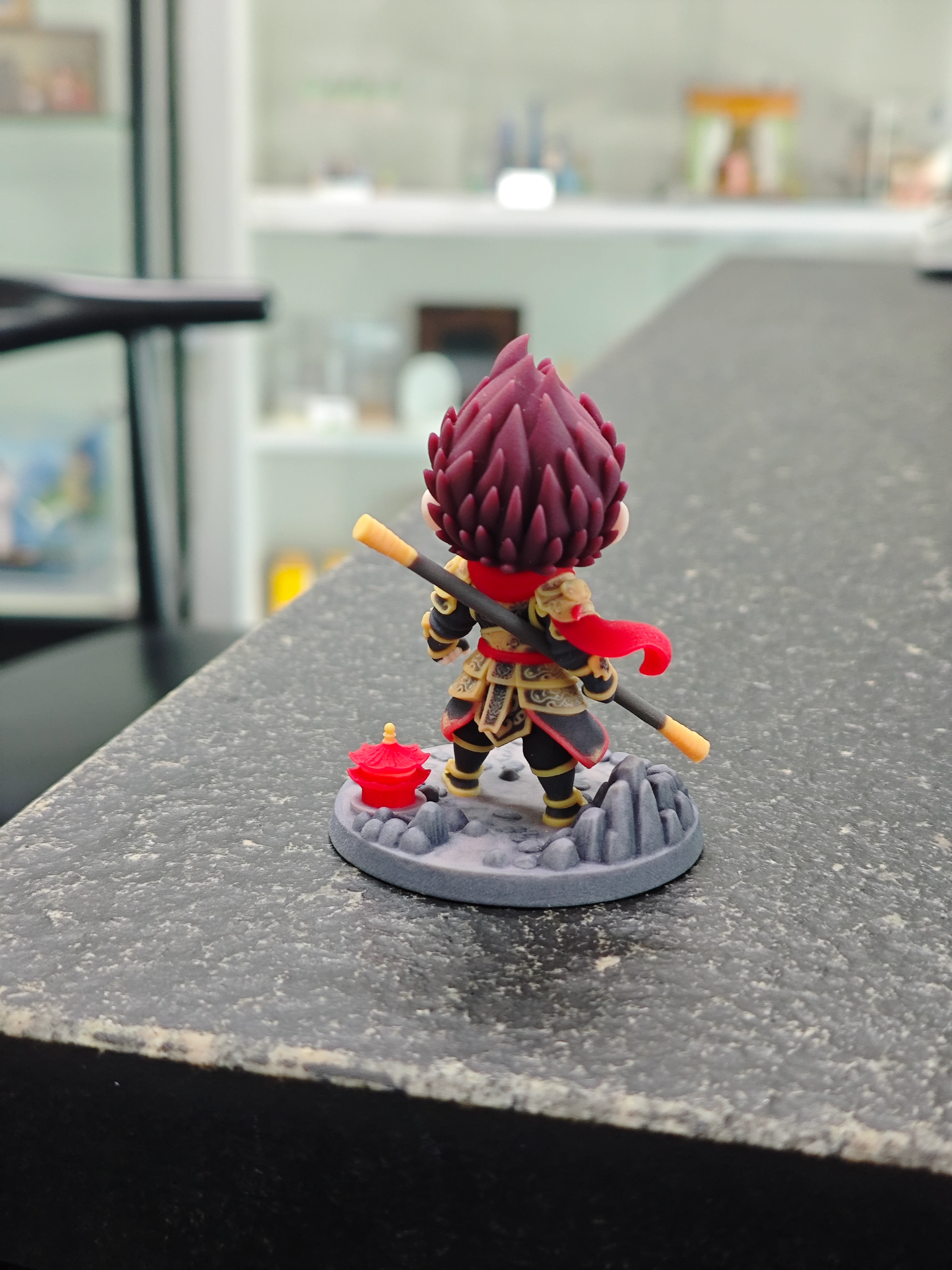 Rear view of a printed fantasy figure with a long scarf and staff